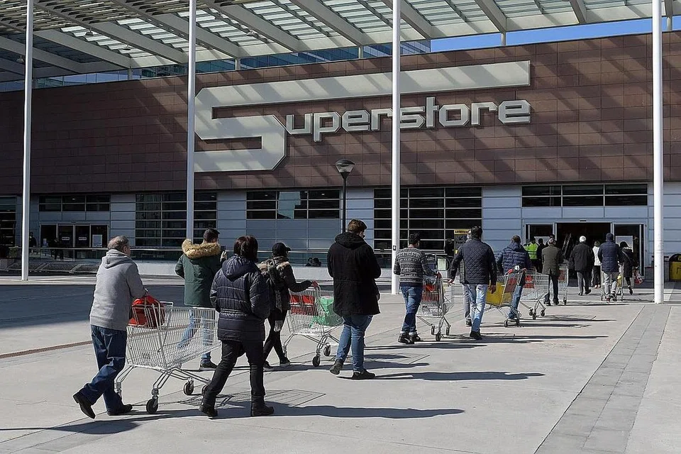 BERATUR PANJANG: Pelanggan terpaksa beratur panjang untuk membeli barangan mereka di sebuah pasar raya ekoran bilangan pembeli yang dibataskan di pasar raya di kawasan San Donato Milanese, di Milan - Foto EPA-EFE