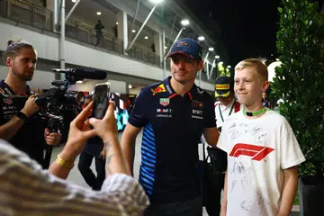 Juara dunia tiga kali dan pemandu Red Bull, Max Verstappen (kiri) bergambar bersama salah seorang peminatnya semasa pelawanan F1 di Singapura baru-baru ini. 