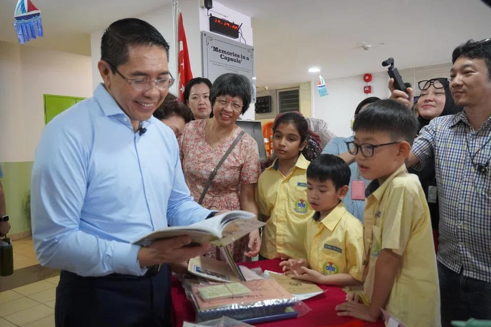 Menteri di Pejabat Perdana Menteri, Dr Mohamad Maliki Osman (kiri), membuka kapsul masa Sekolah Rendah Changkat bersama murid, ibu bapa serta kakitangan sekolah itu, melihat barang yang disimpan di dalamnya selama 10 tahun. 