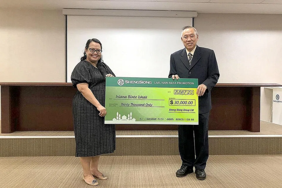 PEMENANG BERTUAH: Cik Iriana menerima replika ceknya dari CEO Kumpulan Sheng Siong, Encik Lim Hock Chee minggu lalu. - Foto SHENG SIONG