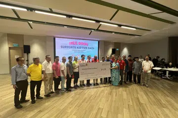 HULUR BANTUAN: Menteri Ehwal Dalam Negeri merangkap Undang-Undang, Encik K. Shanmugam (tengah) dan Menteri Negara (Ehwal Dalam Negeri merangkap Pembangunan Negara), Profesor Madya Dr Muhammad Faishal Ibrahim (sembilan dari kiri)  bergambar bersama ahli akar umbi dan wakil pertubuhan keagamaan serta rakan masyarakat Nee Soon dalam majlis penyampaian cek kepada Yayasan Rahmatan Lil Alamin (RLAF) di Kelab Masyarakat Nee Soon Central pada Sabtu malam.