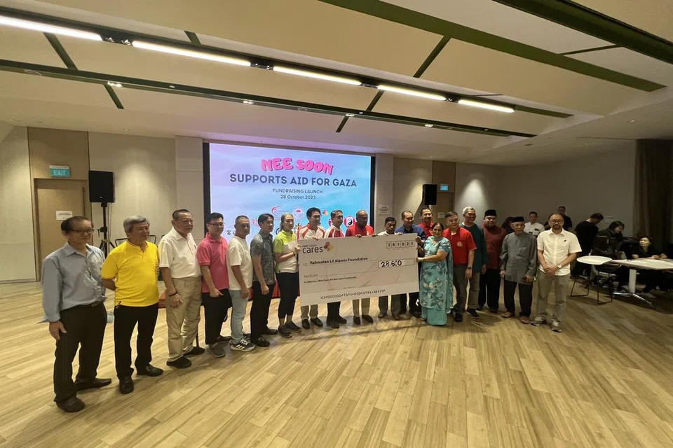 HULUR BANTUAN: Menteri Ehwal Dalam Negeri merangkap Undang-Undang, Encik K. Shanmugam (tengah) dan Menteri Negara (Ehwal Dalam Negeri merangkap Pembangunan Negara), Profesor Madya Dr Muhammad Faishal Ibrahim (sembilan dari kiri)  bergambar bersama ahli akar umbi dan wakil pertubuhan keagamaan serta rakan masyarakat Nee Soon dalam majlis penyampaian cek kepada Yayasan Rahmatan Lil Alamin (RLAF) di Kelab Masyarakat Nee Soon Central pada Sabtu malam.