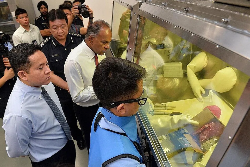 MAKMAL BARU: (Dari kiri) Setiausaha Parlimen Ehwal Dalam Negeri, Encik Amrin Amin; Pesuruhjaya ICA, Encik Clarence Yeo; dan Menteri Undang-Undang merangkap Ehwal Dalam Negeri, Encik K. Shanmugam; meninjau Makmal Analisis Radioaktif dan Nuklear yang baru. - Foto THE STRAITS TIMES