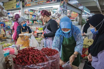 BARANG KERING: Pelanggan memilih cili kering di Pasar Geylang Serai semalam. Kenaikan harga makanan menjejas bukan sahaja makanan laut tetapi juga barangan kering seperti bawang merah, cili kering dan tepung gandum. - Foto BH oleh NUR DIYANA TAHA