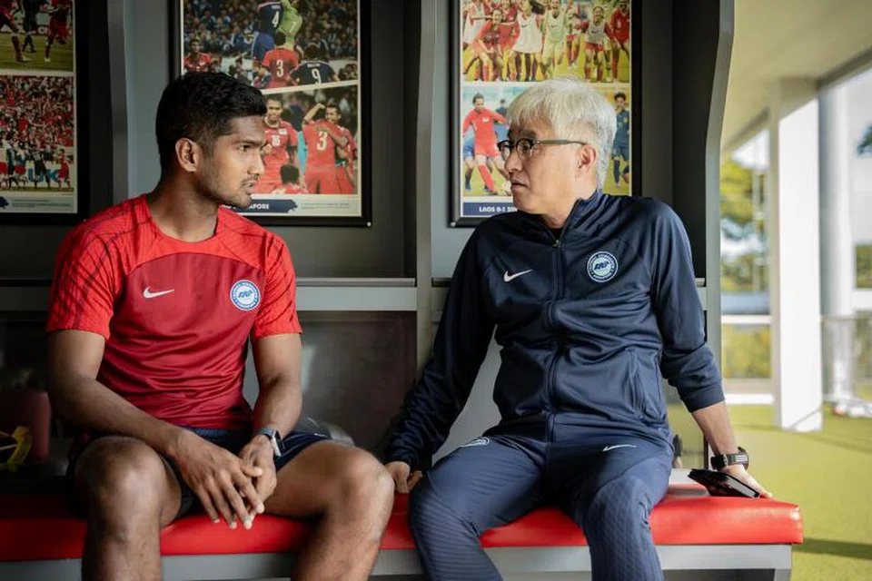 Ogura (kanan) berinteraksi bersama kapten Singapura, Hariss Harun, sebelum latihan pasukan nasional di Hab Bola Sepak Kallang pada 30 Mei.