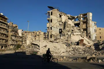 YANG MUSNAH: Seorang lelaki menunggang basikal melepeasi bangunan yang musnah di kawasan yang dikuasai penentang pemerintah Bashar al-Assad, di kejiranan Tariq al-Bab di Aleppo, Syria. - Foto REUTERS