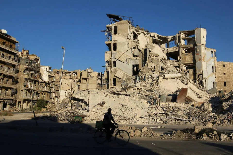 YANG MUSNAH: Seorang lelaki menunggang basikal melepeasi bangunan yang musnah di kawasan yang dikuasai penentang pemerintah Bashar al-Assad, di kejiranan Tariq al-Bab di Aleppo, Syria. - Foto REUTERS