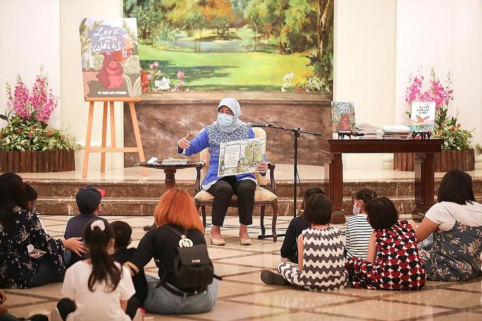 SESI BERCERITA DI ISTANA: Presiden Halimah Yacob membaca buku cerita kepada 28 bekas banduan wanita dan anak-anak mereka dalam rangka lawatan rombongan tersebut ke Istana. - Foto ZAOBAO