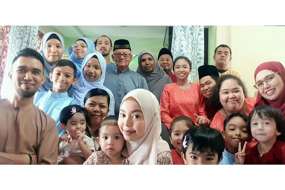 GILIR-GILIR JUMPA: Encik Mohammad Faizal (paling kiri) akan bergilir-gilir dengan adik-beradik serta ahli keluarganya untuk berjumpa dengan ibu bapanya, Cik Rokia Md Hassan (tengah, berbaju kelabu) dan Encik Mansor Abdullah (tengah, berkaca mata), sedang Singapura melonggarkan sekatan setelah tempoh pemutus litar. Gambar diambil ketika sambutan Hari Raya tahun lalu. - Foto ihsan MOHAMMAD FAIZAL SAFIE