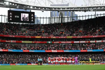 Kekuatan Arsenal musim ini hasil daripada pasukan yang bersatu dan sokongan utuh penyokong. Gambar ini menunjukkan pasukan itu semasa tempoh berkabung seminit untuk meraikan sumbangan bekas pengurus prasarana stadium Mark Pearce yang meninggal dunia pada Oktober 2025.  