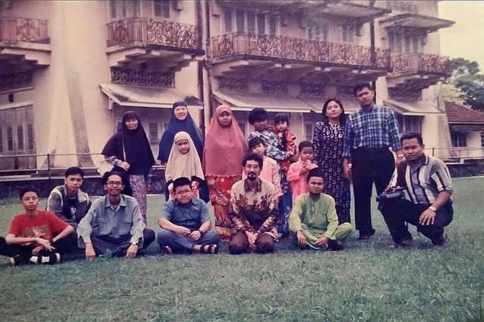 PEMBACA HANTAR GAMBAR SELEPAS BACA LAPORAN: Kami pernah tinggal di Istana Woodneuk - GAMBAR KENANGAN: Encik Razali Hassan (kanan, berkemeja belang) telah menghubungi Encik Sarafian dan Berita Harian selepas membaca bahagian pertama laporan 'Istana Silam di Singapura' minggu lalu. Beliau telah berkongsi gambar dan maklumat mengenai istana itu. Menurut Encik Razali, beliau dan isterinya, Cik Siti Rahayu Jambari (baris belakang, berdiri, bertudung jingga), bersama keluarga mereka pernah tinggal di Istana Woodneuk dari 1989 hingga 1999. Ibu mertuanya telah tinggal di Istana Woodneuk sejak kecil pada 1954. Datuk dan neneknya pernah berkhidmat dengan Sultan Johor sebagai pekebun di Istana Woodneuk. - Foto ihsan ENCIK RAZALI HASSAN