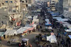 Rakyat Palestin berjalan di pasar sebelum gencatan senjata antara Israel dan Hamas dijadual berkuat kuasa di Khan Younis, Gaza pada 19 Januari.