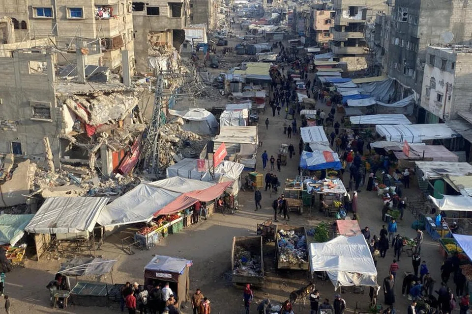 Rakyat Palestin berjalan di pasar sebelum gencatan senjata antara Israel dan Hamas dijadual berkuat kuasa di Khan Younis, Gaza pada 19 Januari.