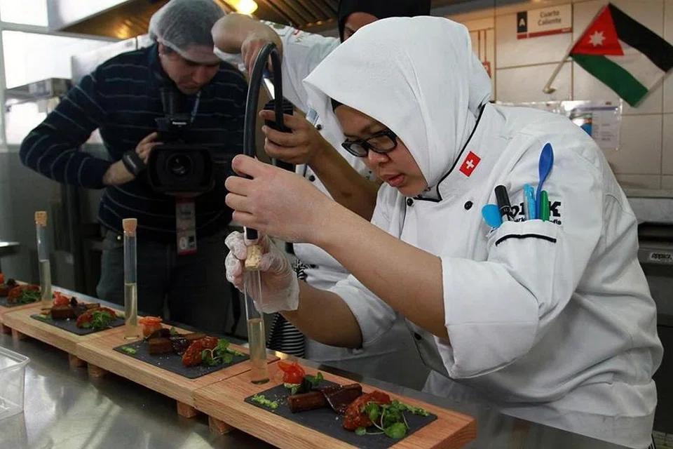MERAIH PINGAT EMAS: Cik Siti Zakiah (kanan) sewaktu menyediakan hidangan bagi pertandingan Laureate Culinary Cup di Chile pada 2014 mewakili negara Jordan, yang menyaksikan pasukan beliau muncul sebagai naib juara dengan pingat emas cemerlang. - Foto ihsan SITI ZAKIAH ZAKARIA