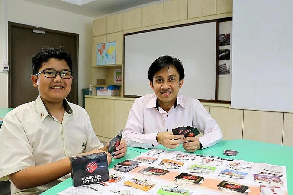 SERONOK BERMAIN: Duta Pendidikan Nasional, Irfan Yusry (kiri) dan gurunya, Cikgu Mohamed Shahmir, sependapat bahawa permainan kad GOTC merupakan cara menyeronokkan mempelajari tentang Pertahanan Mutlak.