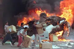 Kumpulan perusuh Indonesia membakar kereta dan perniagaan Cina ketika mereka merompak kedai di Jakarta pada 14 Mei 1998.