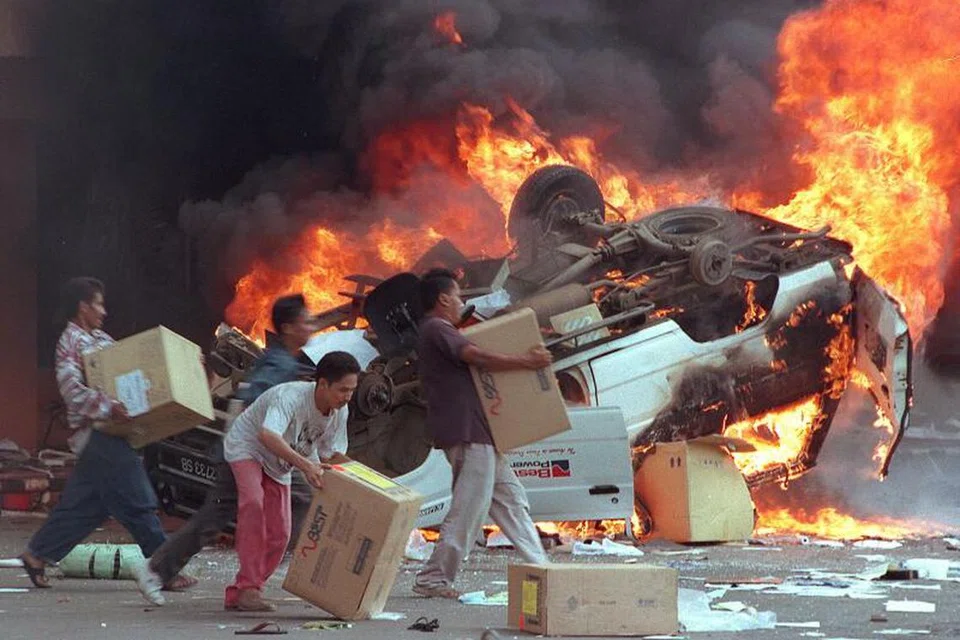 Kumpulan perusuh Indonesia membakar kereta dan perniagaan Cina ketika mereka merompak kedai di Jakarta pada 14 Mei 1998.