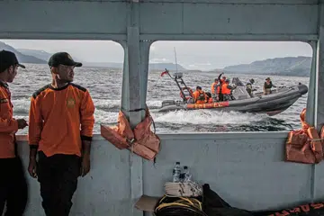 MENCARI DAN MENYELAMAT: Para pegawai penyelamat meneruskan usaha mencari mangsa-mangsa feri karam Danau Toba berdekatan Pelabuhan Tigaras, Simalungun, Sumatra. - Foto AFP