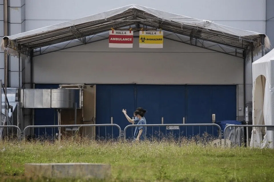 Pekerja jagaan kesihatan melalui Dewan 4 Singapore Expo pada Jumaat lalu. - Foto KELVIN LIM