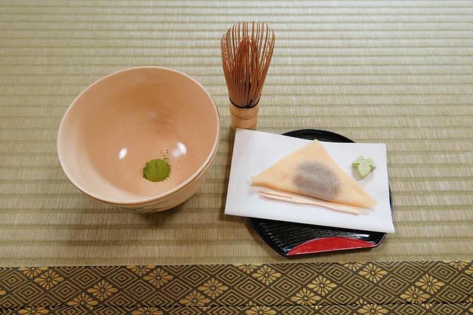 Kelengkapan asas upacara teh yang merangkumi mangkuk berisi serbuk matcha, pemukul buluh (chasen), dan manisan tradisional Jepun (wagashi) yang dihidangkan untuk mengimbangkan rasa pahit teh.