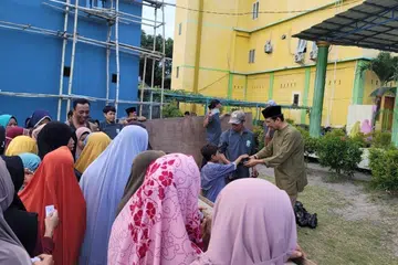 Wakil Al-Imtaq International & Services,Ustaz Sharif Shahar (bersongkok hitam, berbaju Melayu) mengagihkan bantuan daging korban daripada masyarakat Islam Singapura kepada masyarakat Islam kurang bernasib baik seperti fakir miskin, ibu tunggal, dan anak-anak yatim yang tinggal di kawasan pedalaman Lombok, Indonesia, dalam acara korban Al-Imtaq International & Services pada 29 Jun 2023. 
