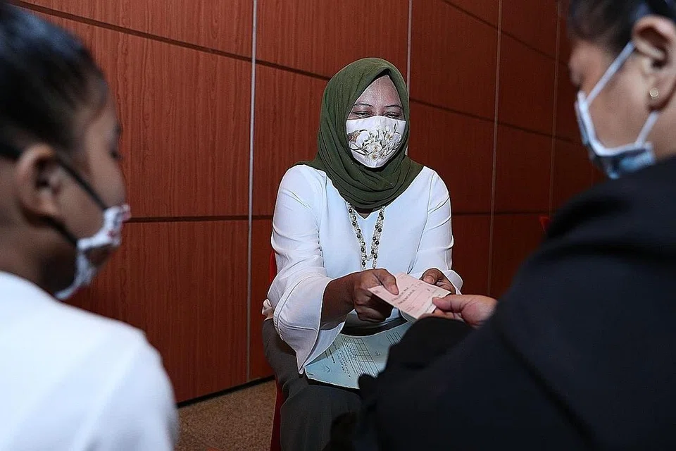 TERIMA BANTUAN: Cik Jamilah (bukan nama sebenar) menerima cek daripada setiausaha kehormat HGEF, Cik Haslinda Putri Harun, dalam satu majlis di Kelab Masyarakat Bukit Batok East semalam. - Foto BH oleh TIMOTHY DAVID