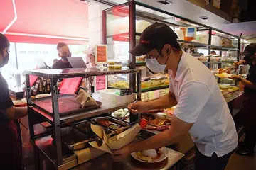 PRIHATIN: Pengurus Rumah Makan Minang, Encik Hazmi (gambar atas baju putih), mengalu-alukan pendekatan lebih tegas oleh pemerintah demi memastikan semua mengikuti langkah pengurusan selamat, namun beliau turut melahirkan keprihatinan kerana ada segelintir pelanggan yang berkeras tidak menuruti peraturan walaupun sudah diingatkan berulang kali dan beliau bimbang pihaknya akan dipertanggungjawabkan. - Foto BH oleh MARK CHEONG