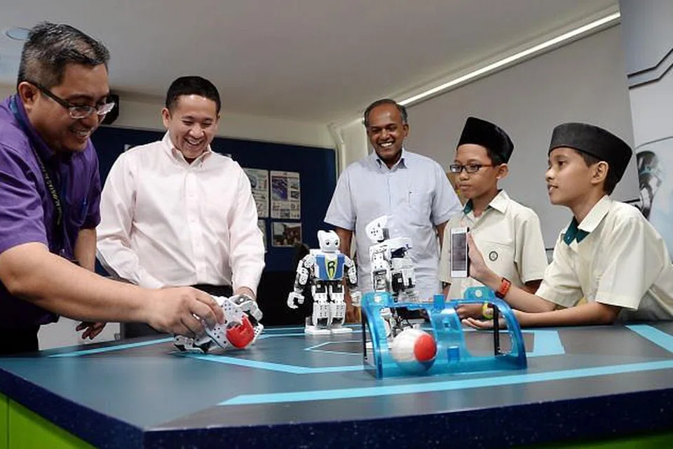 TINJAU MAKMAL DI IRSYAD: Menteri Dalam Negeri, Encik K. Shanmugam (kanan), yang ditemani Setiausaha Parlimen, Encik Amrin Amin, melihat dari dekat makmal Stem (sains, teknologi, kejuruteraan, matematik) Madrasah Al-Irsyad. Bersama mereka ialah guru di makmal itu, Encik Mohd Fadilah Ahmad (kiri), serta murid darjah lima madrasah itu, Sadi Azfar Suhaimi (berkaca mata) dan Musab Zailan. - Foto JOHARI RAHMAT