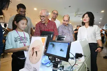 Menteri Pembangunan Sosial dan Keluarga, Encik Masagos Zulkifli Masagos Mohamad (tiga dari kiri);  Menteri Negara Kanan (Pendidikan merangkap Kemampanan dan Sekitaran), Dr Janil Puthucheary (tiga dari kanan); Setiausaha Parlimen Kanan (Pendidikan merangkap Pembangunan Negara), Dr Syed Harun Alhabsyi (dua dari kanan); dan Penasihat kepada Pertubukan Akar Umbi GRC Aljunied, Cik Chan Hui Yuh, berinteraksi dengan orang ramai di Karnival Masyarakat Ulang Tahun ke-10 Projek Wolbachia pada 31 Oktober.