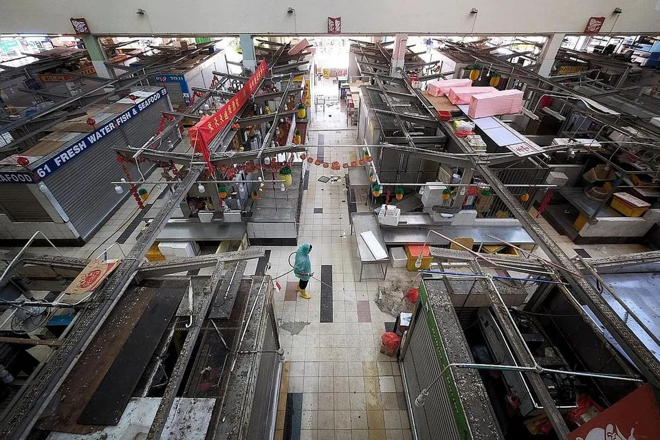 PASAR BASAH DITUTUP: Seorang pekerja membersihkan kawasan pasar basah di tingkat satu Pusat Tekka yang ditutup semalam hingga esok selepas beberapa kes jangkitan Covid-19 dikesan di sana. - Foto BH oleh GAVIN FOO 