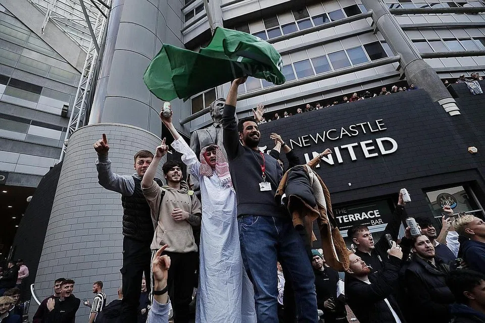 DIALU-ALU PENYOKONG: Penyokong merai berita mengenai perubahan pemilikan Newcastle di luar stadium St James' Park kelmarin. - Foto REUTERS