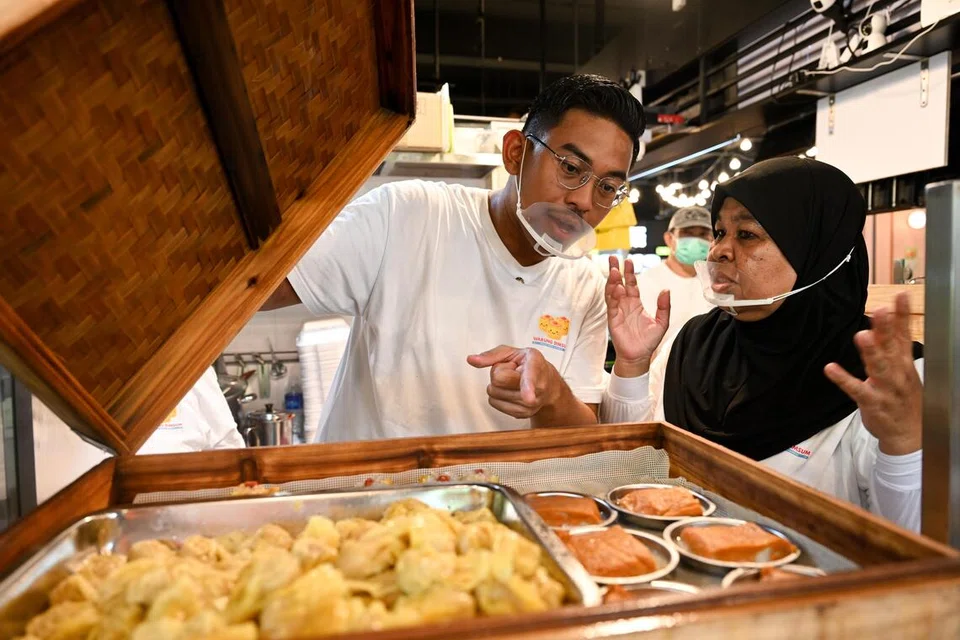 Encik Imran bersama ibunya, Cik Fauziah Shaharuddin, 60 tahun, yang aktif membantu anaknya di gerai yang terletak di Yishun. 