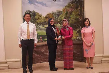 PENGIKTIRAFAN TERTINGGI: Cik Nirmala (dua dari kiri) menerima Anugerah Presiden bagi Jururawat dari Presiden Halimah yang turut dihadiri Encik Ong (kiri) dan Cik Koh.