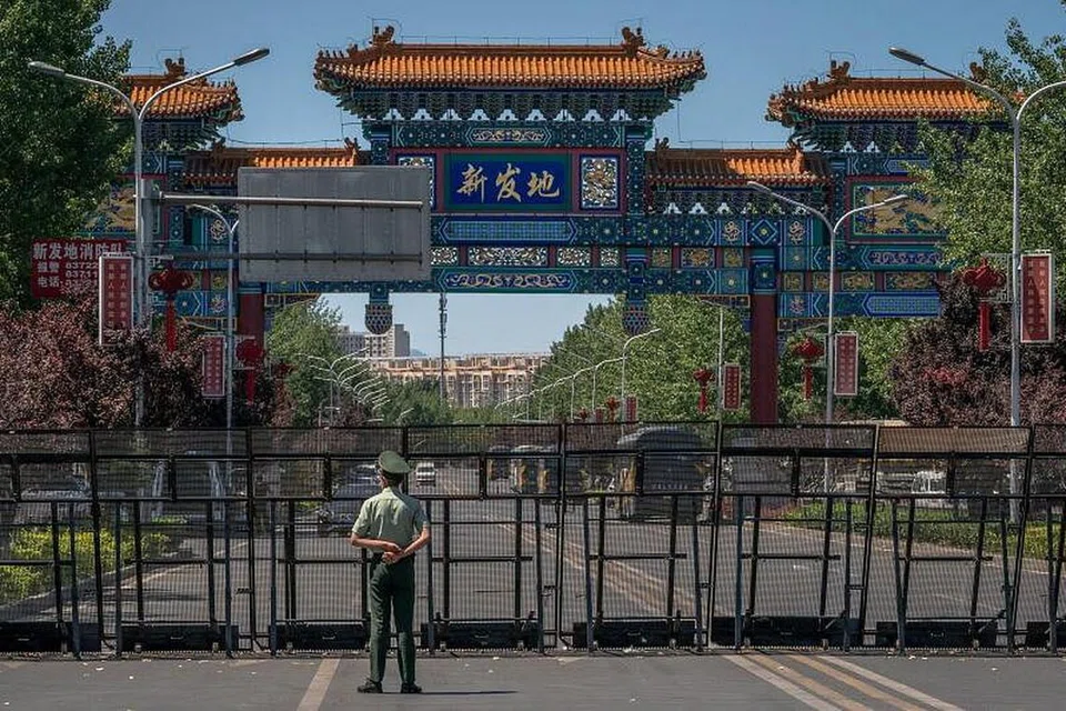 Seorang pegawai keselamatan berdiri di luar pasar Xinfadi di Beijing, China, yang ditutup berikutan pengesahan kes koronavirus domestik baru yang dikaitkan dengan tempat itu. - Foto EPA