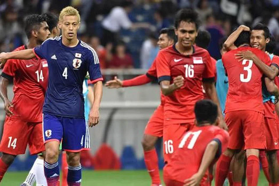 CURI SATU MATA: Pasukan Singapura meraikan kejayaan mereka mengikat Jepun 0-0 di Stadium Saitama dan kini mendahului Kumpulan E. - Foto AFP