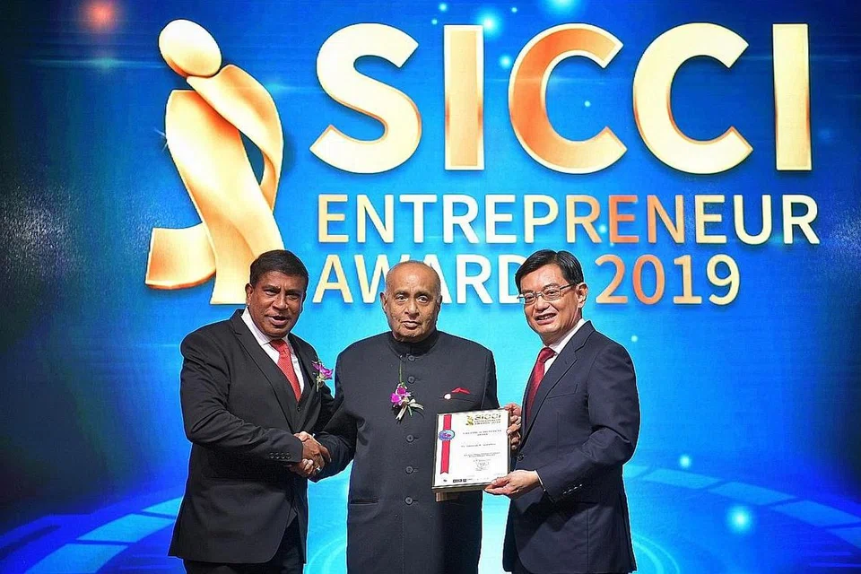 BAKTINYA DIKENANG: Allahyarham Ameerali Rajabali Jumabhoy (tengah), yang meninggal dunia semalam pada usia 94 tahun, semasa menerima Anugerah Pencapaian Sepanjang Hayat 2019 oleh Dewan Perniagaan dan Perusahaan India Singapura (SICCI), bersama Timbalan Perdana Menteri Heng Swee Keat (kanan) dan pengerusi SICCI, Dr T. Chandroo. - Foto fail