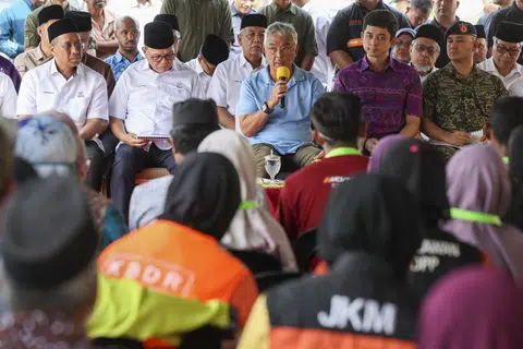 SANTUNI MANGSA BANJIR: Yang di-Pertuan Agong (duduk tengah) melawat Pusat Penempatan Sementara (PPS) Dewan Semai Bakti, Felda Chini Satu pada 11 Januari.