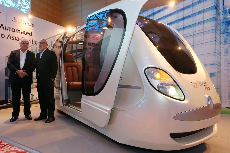 TREND KENDERAAN TANPA PEMANDU: Encik Carel van Helsdingen (kiri) bersama Encik Colin Lim menunjukkan replika Pengangkutan Gerak Cepat Peribadi (PRT) yang boleh membawa empat penumpang. - Foto THE STRAITS TIMES
