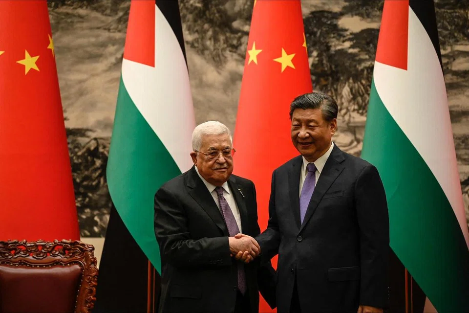JALIN IKATAN: Presiden Palestin, Encik Mahmud Abbas (kiri), berjabat tangan dengan Presiden China, Encik Xi Jinping, selepas satu upacara penandatanganan di Beijing pada 14 Jun.