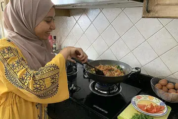 LUANGKAN MASA DI DAPUR: Bekerja dari rumah membolehkan penulis lebih banyak memasak untuk keluarganya juga. - Foto BH oleh NUR FATHIN AWALLUDIN