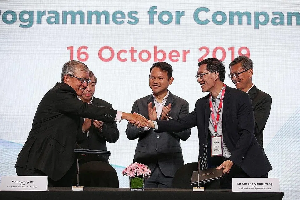 TAWAR PROGRAM DIGITAL: Kerjasama dijalin antara SBF dan NUS-ISS agar syarikat dan pekerja dapat meraih manfaat dalam usaha pendigitalan mereka. Encik Zaqy (tengah) telah menyaksikan pemeteraian MOU semalam, yang ditandatangani oleh (depan, dari kiri) Encik Ho Meng Kit, CEO SBF dan Encik Khoong Chong Meng, CEO NUS-ISS. - Foto BH oleh KEVIN LIM