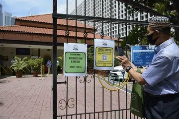 Jemaah mengimbas kod QR bagi penjejakan kontak sebelum masuk ke Masjid Omar Kampong Melaka. - Foto MUIS 