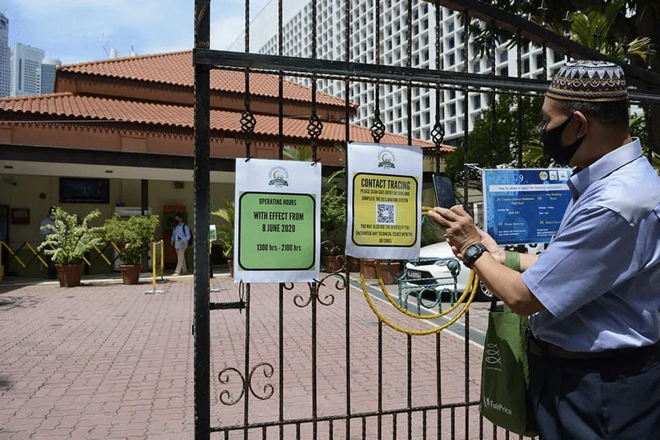 Jemaah mengimbas kod QR bagi penjejakan kontak sebelum masuk ke Masjid Omar Kampong Melaka. - Foto MUIS 