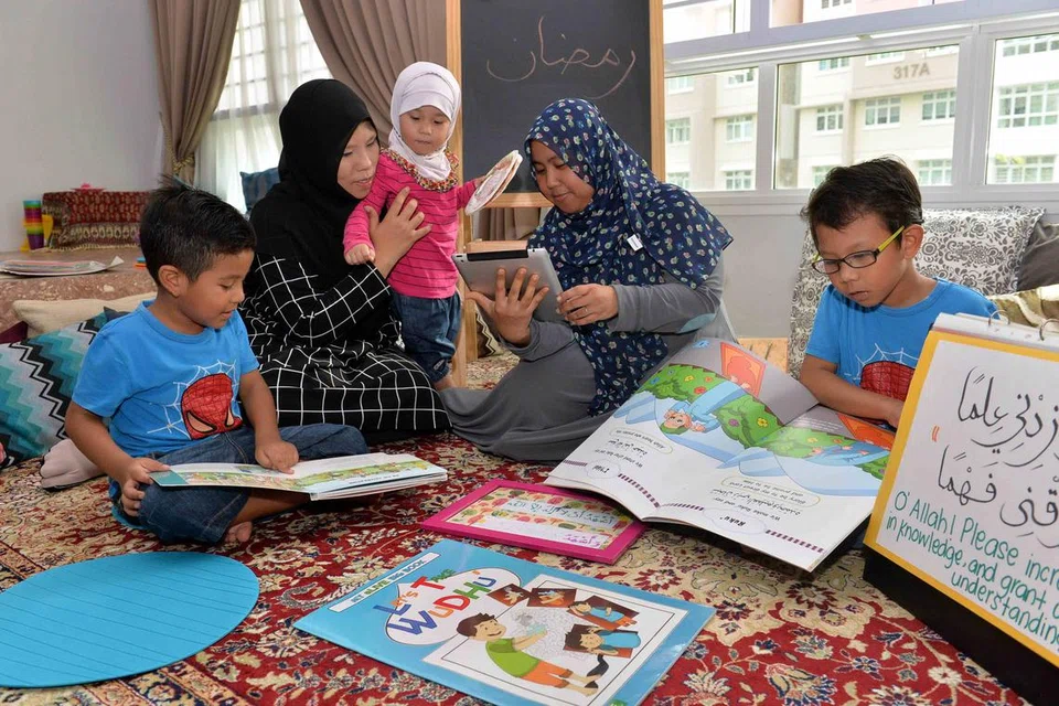BERGABUNG MENGAJAR: Cik Adawiyah (berbaju hitam) dan Cik Siti Nurzakiah (bertudung biru) mengajar anak-anak mereka bersama seminggu sekali di rumah Cik Siti Nurzakiah di Yishun. Bersama mereka adalah anak-anak Cik Adawiyah (dari kiri) Muhamad Haziq, Aliyah Hasya dan Muhamad Hasbi. - Foto M.O. SALLEH