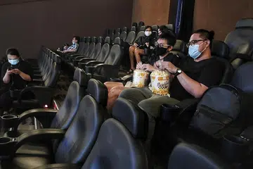 UBATI RINDU TENGOK WAYANG: Beberapa penonton seperti (dari kiri, memegang bertih jagung) Encik Thomas Chih dan Encik Cortez pagi-pagi lagi sudah berada di pawagam Shaw Theatres di Nex yang dibuka semula selepas lebih tiga bulan ditutup. - Foto BH oleh KELVIN CHNG