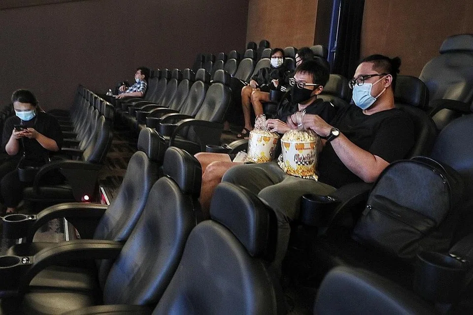 UBATI RINDU TENGOK WAYANG: Beberapa penonton seperti (dari kiri, memegang bertih jagung) Encik Thomas Chih dan Encik Cortez pagi-pagi lagi sudah berada di pawagam Shaw Theatres di Nex yang dibuka semula selepas lebih tiga bulan ditutup. - Foto BH oleh KELVIN CHNG