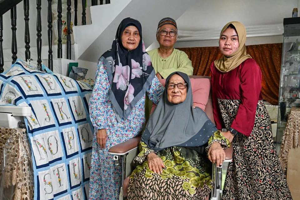 (Dari kiri) Cik Fareha Mohd Jaafar, Encik Mohamad Rihat Mohamad Tahir, Cik Aminah Puteh (duduk), dan pembantu rumah Cik Indriani. 
