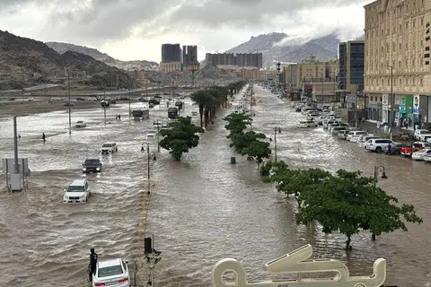 Para pengguna jalan raya meredah laluan yang ditenggelami air selepas hujan lebat melanda Makkah pada 7 Januari.