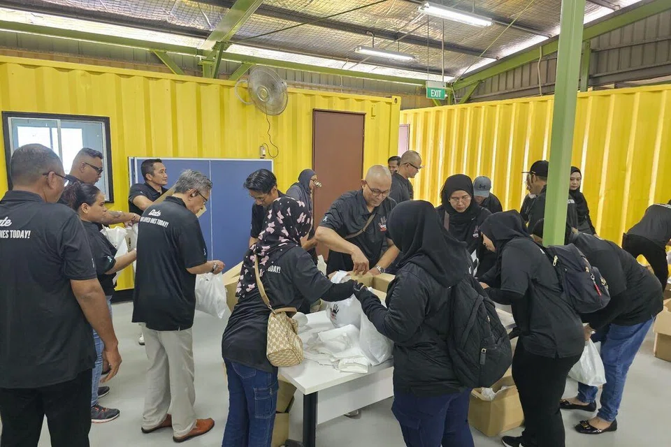 Sukarelawan ‘Dadah Itu Haram’ membungkus bubur dan kurma di pusat Perkhidmatan Masyarakat Mawar (MCS) pada 1 Mac.