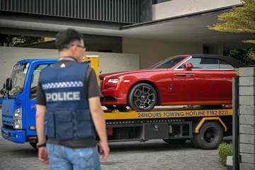 DIRAMPAS: Salah satu daripada empat kereta mewah yang dikaitkan dengan kes pengubahan wang haram terbesar di Singapura yang ditarik keluar dari sebuah Banglo Kelas Baik (GCB) di Third Avenue pada Rabu.